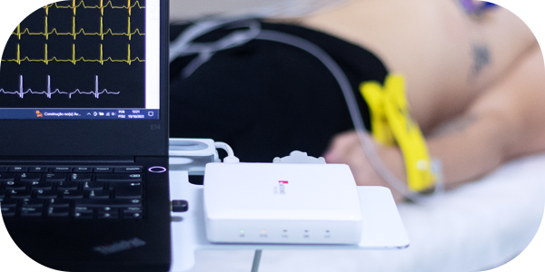 Equipamento de ECG em uso, mostrando o traçado do eletrocardiograma em uma tela.