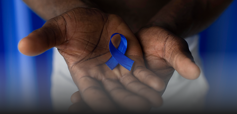 Mãos de um homem segurando um laço azul, símbolo da campanha Novembro Azul de prevenção ao câncer de próstata.